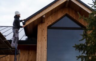Roofing workers installing or inspecting a wooden roof on a modern house.
