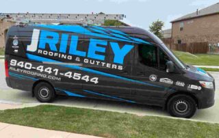 J. Riley Roofing & Gutters service van parked in a residential neighborhood.
