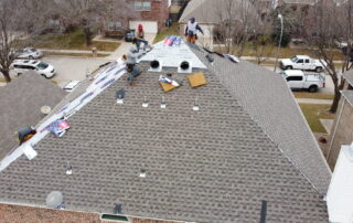 Roofing crew installing new gutters on a residential home in a neighborhood.